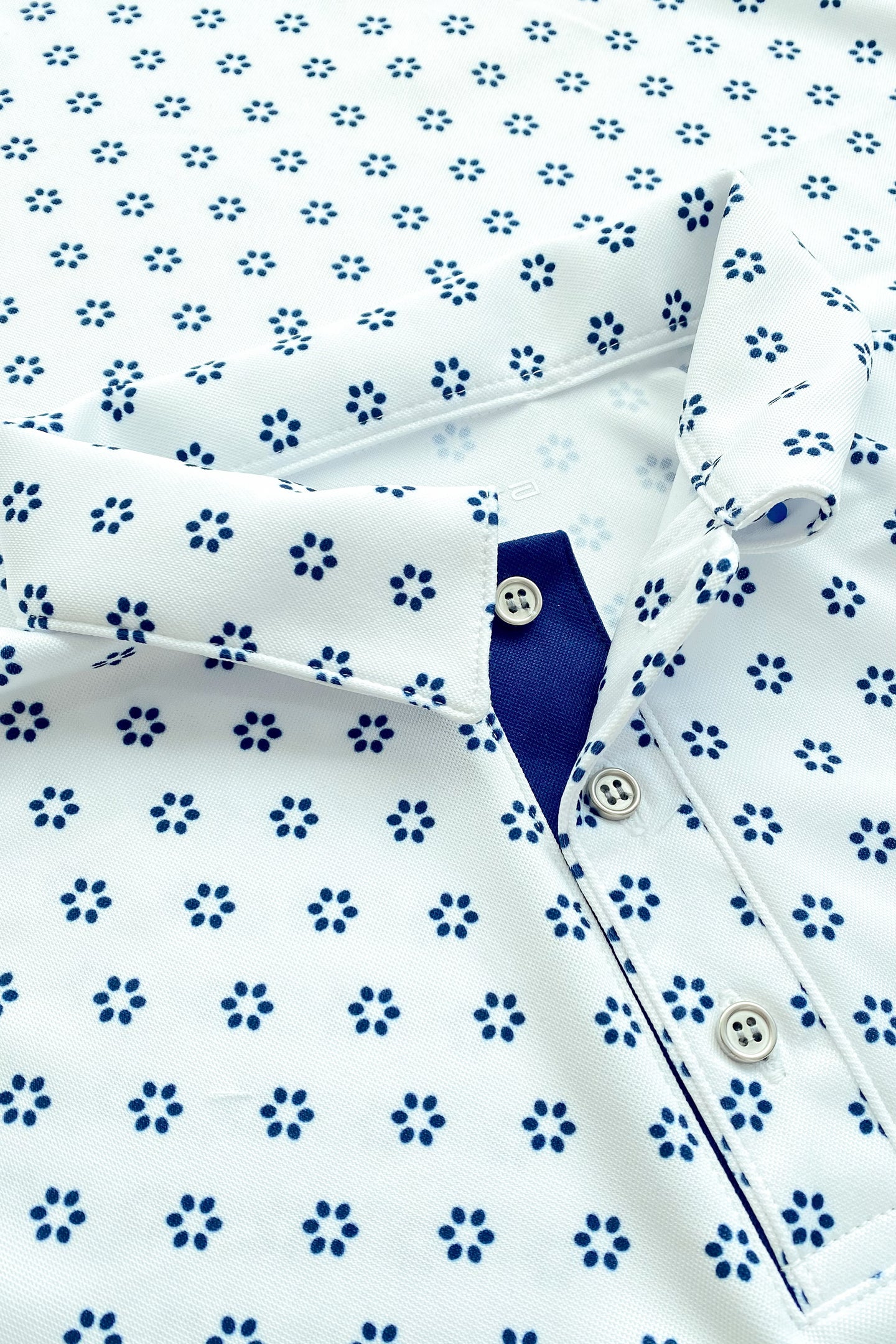 Polo de golf blanca con estampado azul. Tecnología dryfit, fresca y cómoda para tu mejor swing. Envíos en todo México.