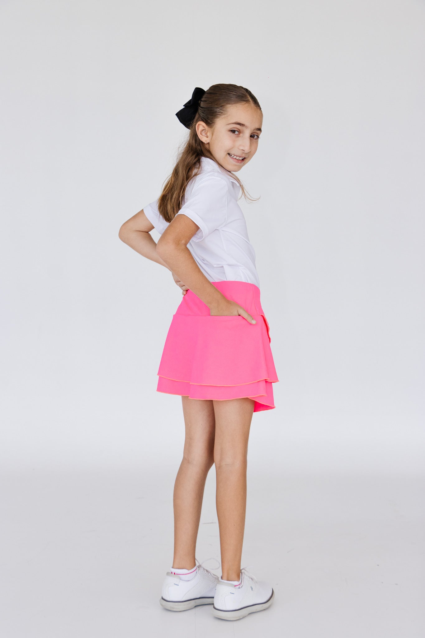 Falda de golf o peal para niña con corte tulipán, lycra dryfit y bolsa trasera, color rosa fosforescente