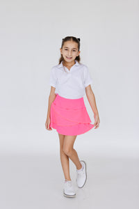 Falda de golf para niña corte tulipán color rosa fosforescente, con lycra dryfit y bolsillo trasero